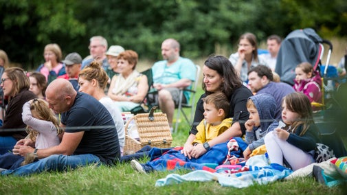 Families watching an open air theatre performance
